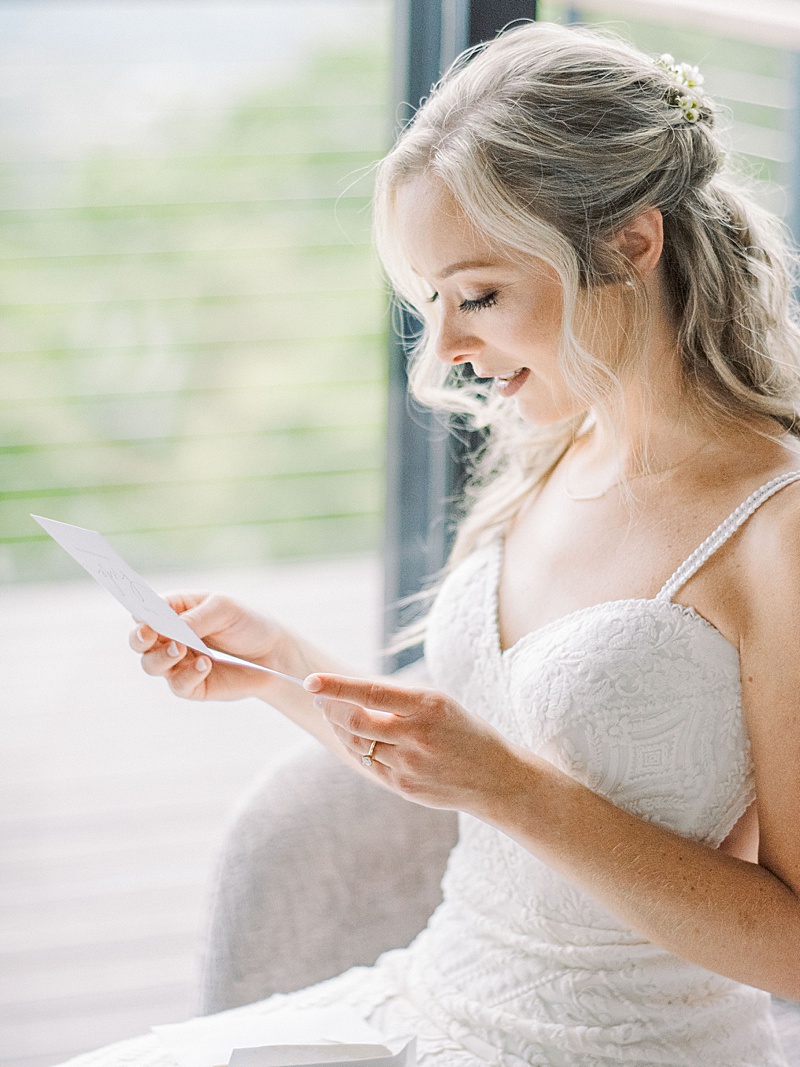 Bride reading a letter from her soon-to-be husband on their wedding day.